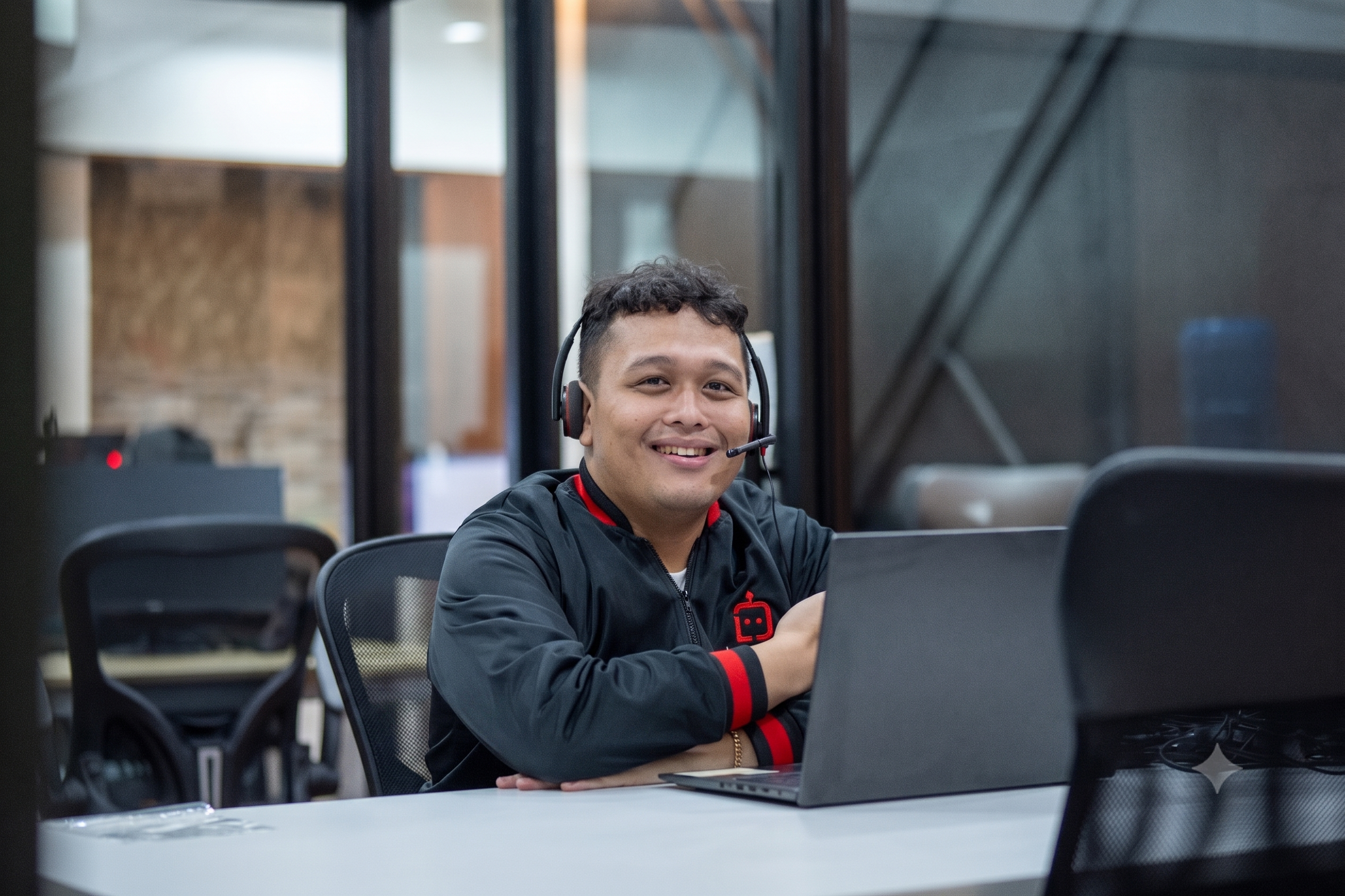 Smiling virtual assistant wearing a headset in front of a laptop