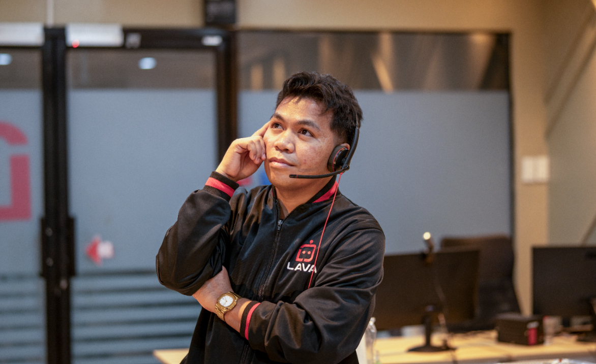 A man thinking and wearing a lava jacket while he is on his headphone 