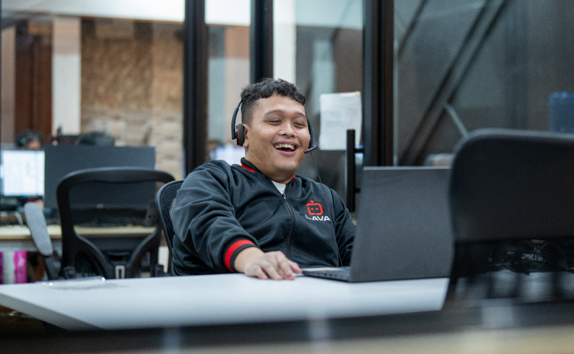 Lava automations virtual assistant looking happy while looking on a laptop screen