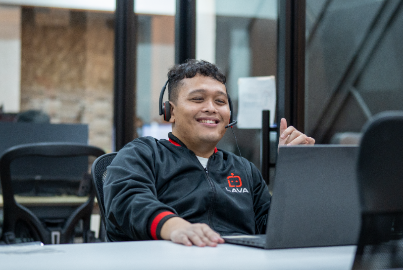 Lava Employee checking his laptop while smiling 