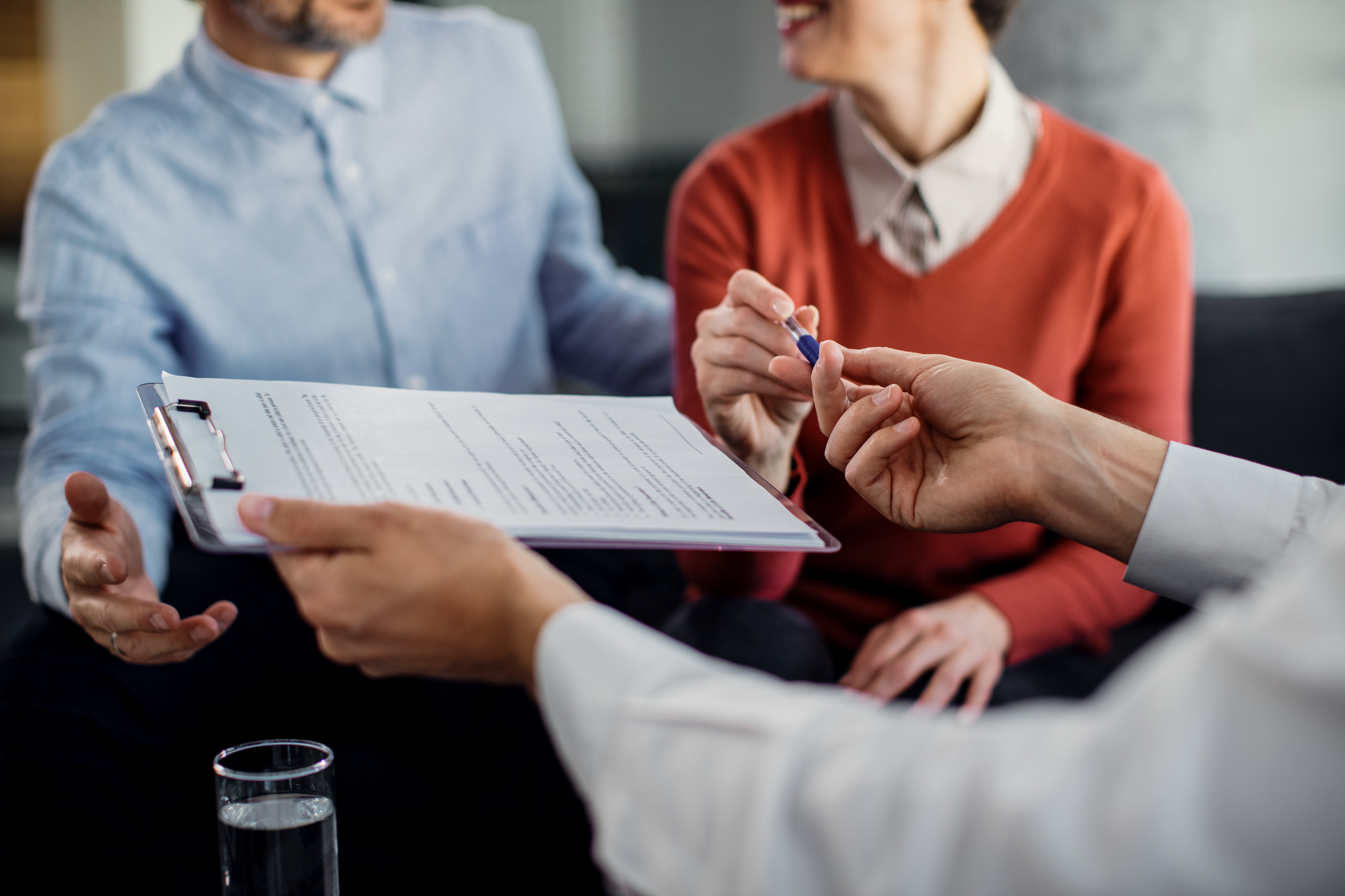 Insurance agent handing over a pen to a client