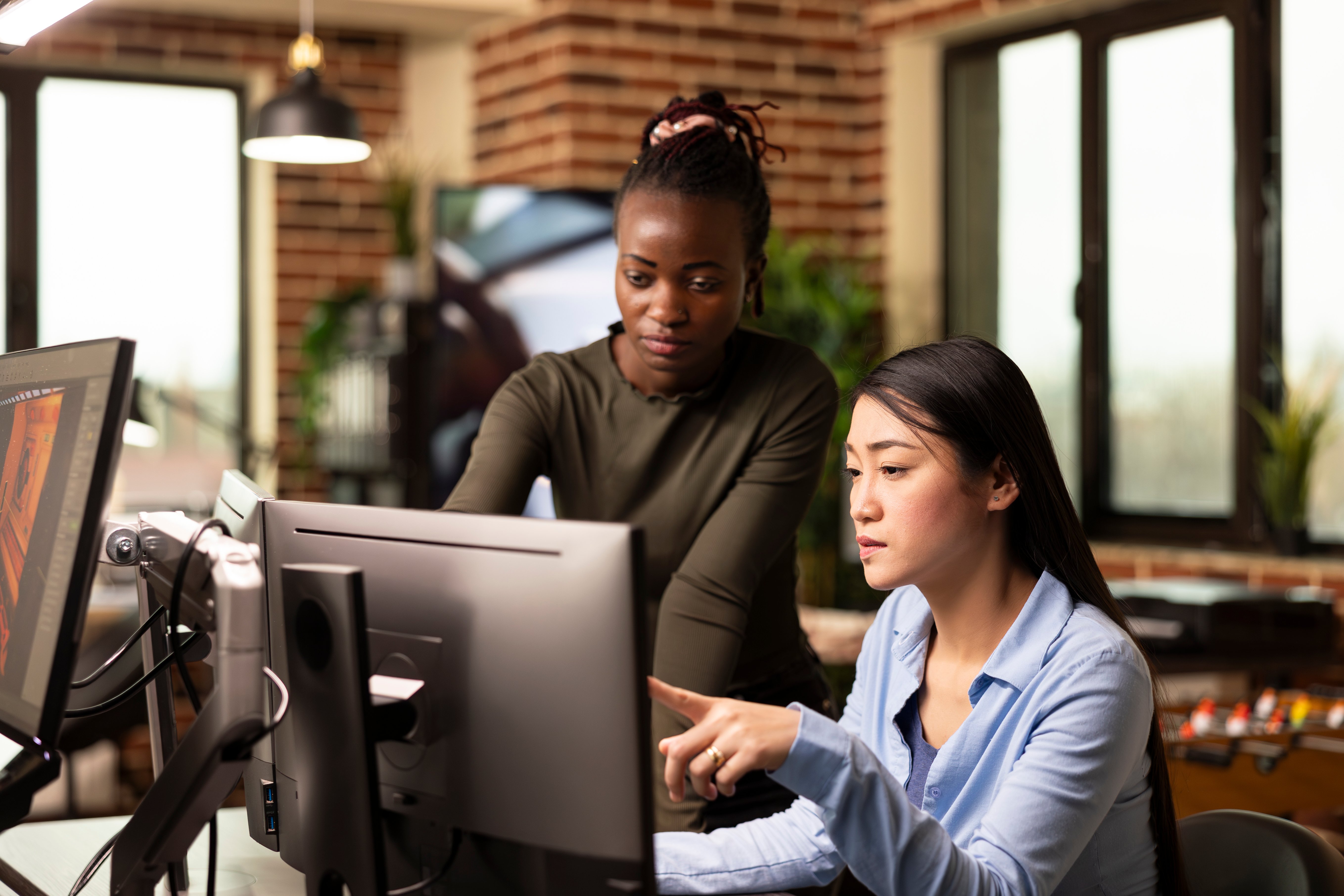 Two coworkers analyzing data on computer