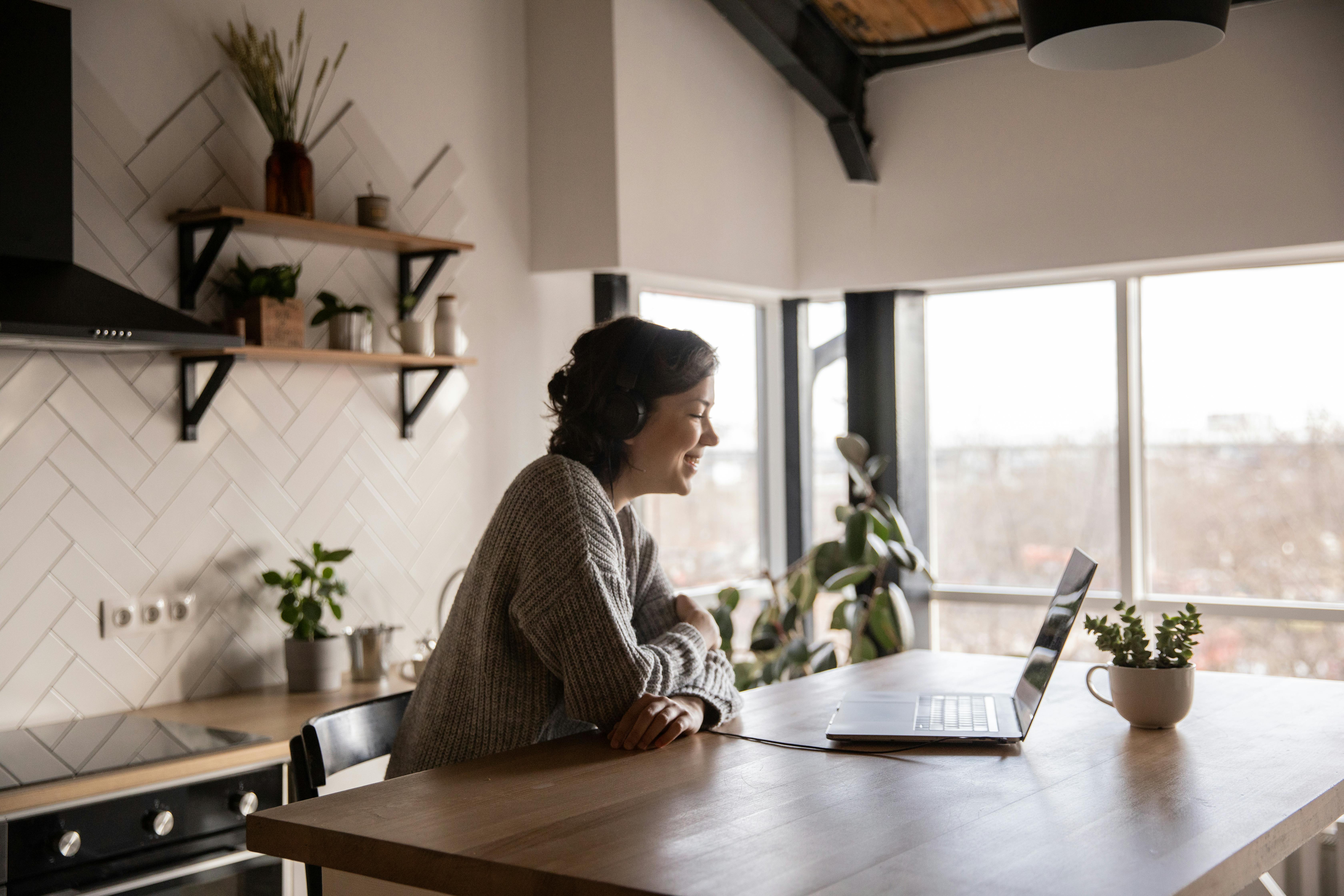 Remote professional smiling during a video call on a laptop at home workspace
