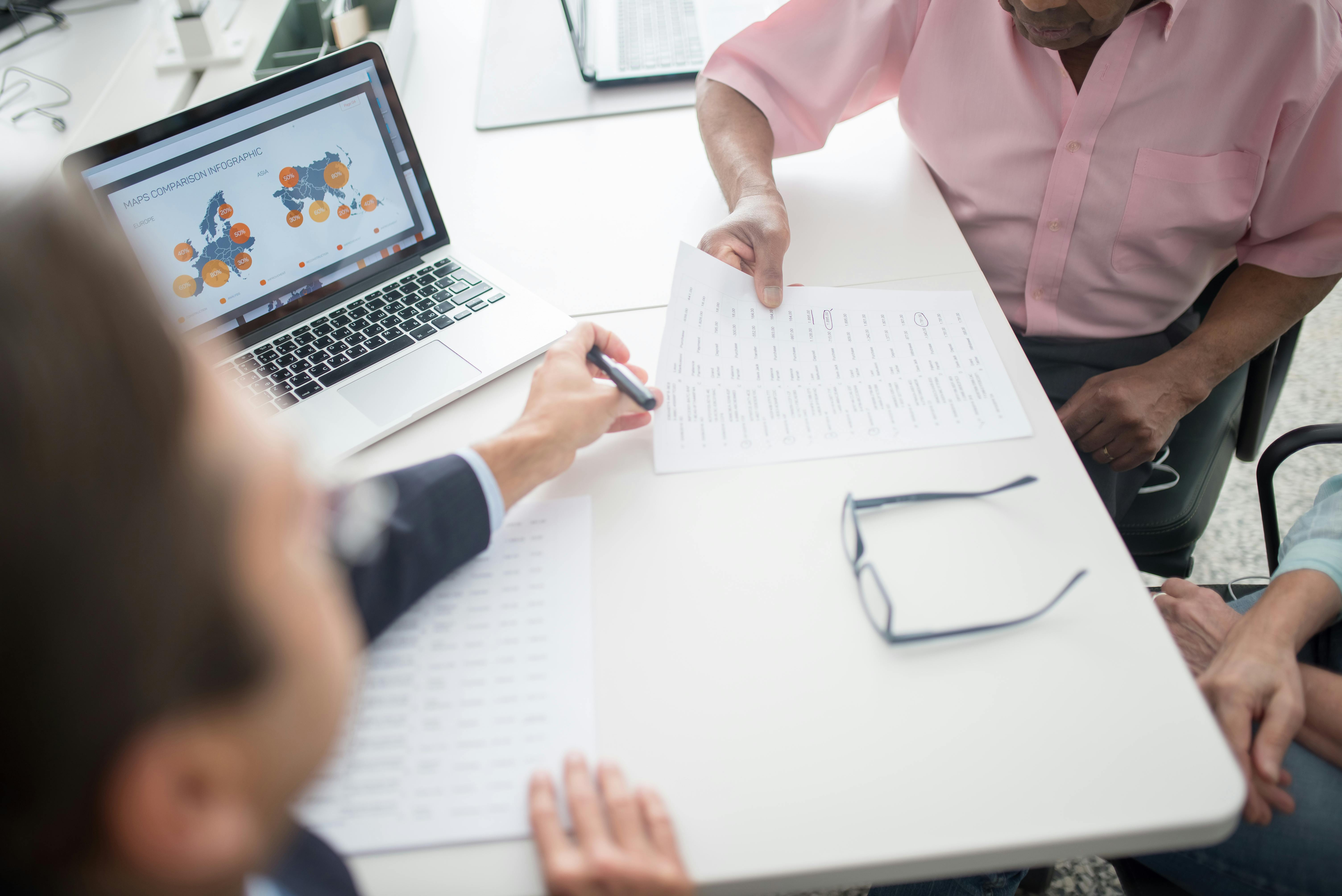 Business professionals reviewing documents and data charts during a meeting