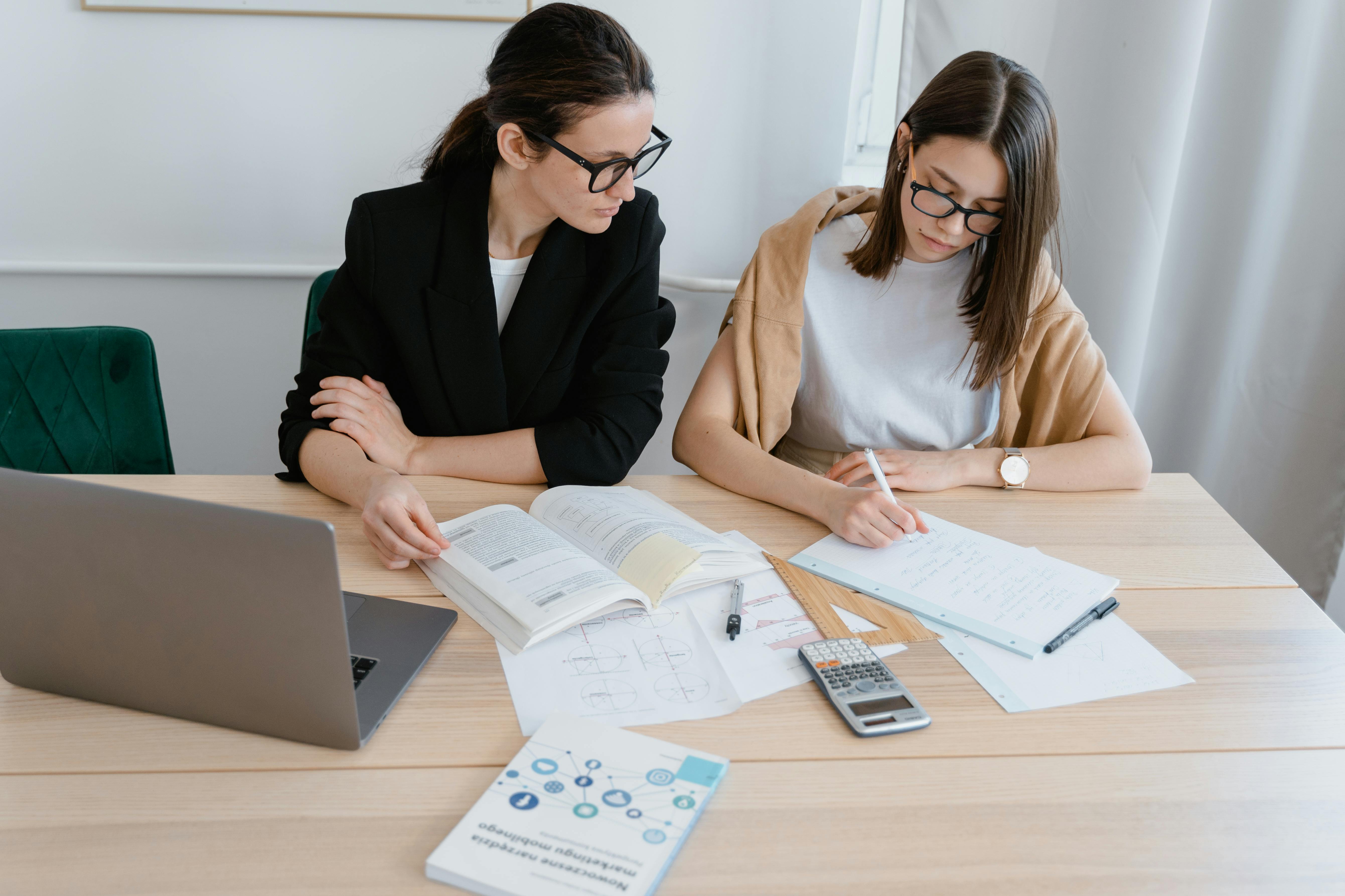Manager providing training to an employee at a desk.