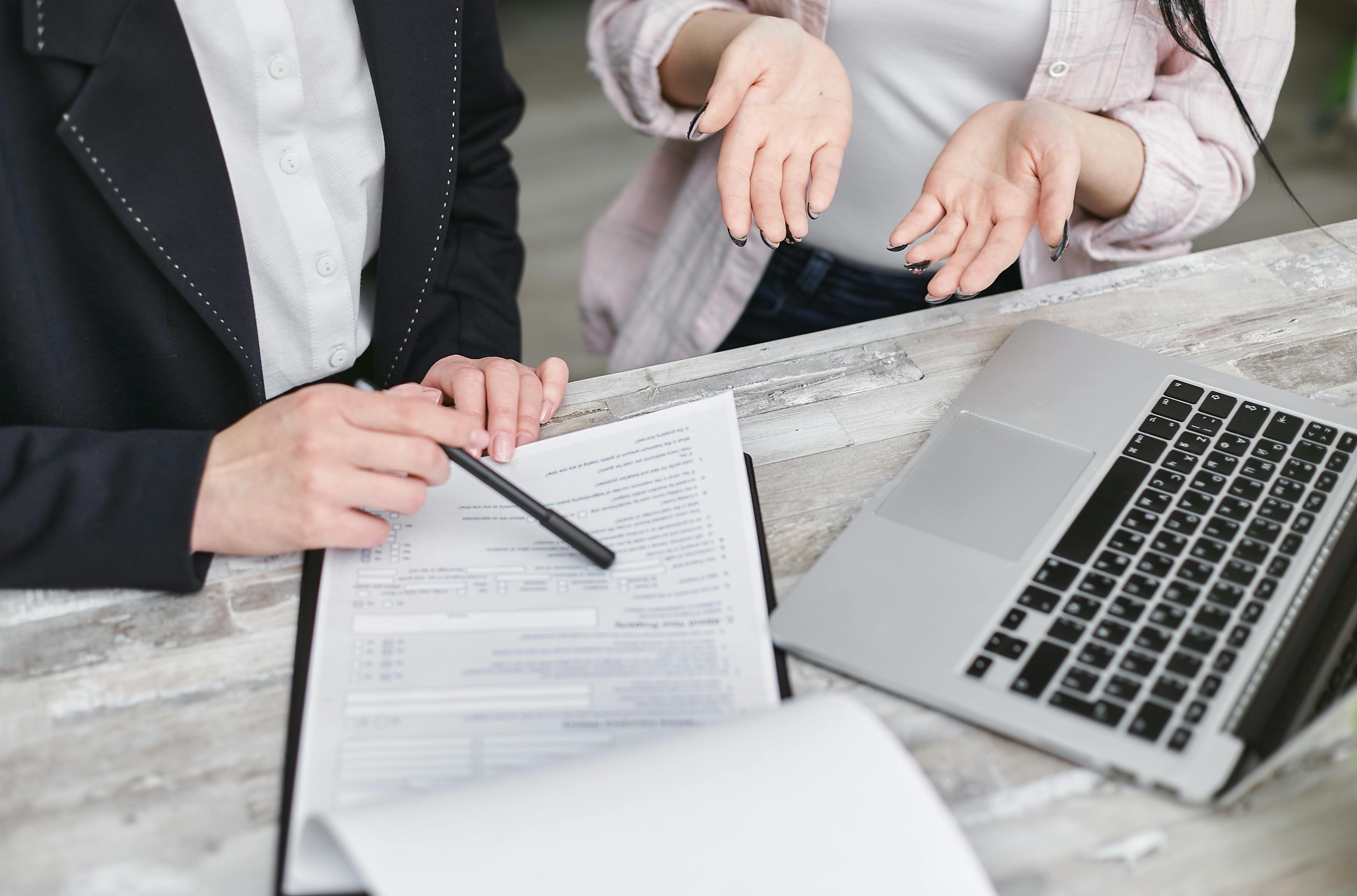 Two people reviewing insurance agency documents at a desk