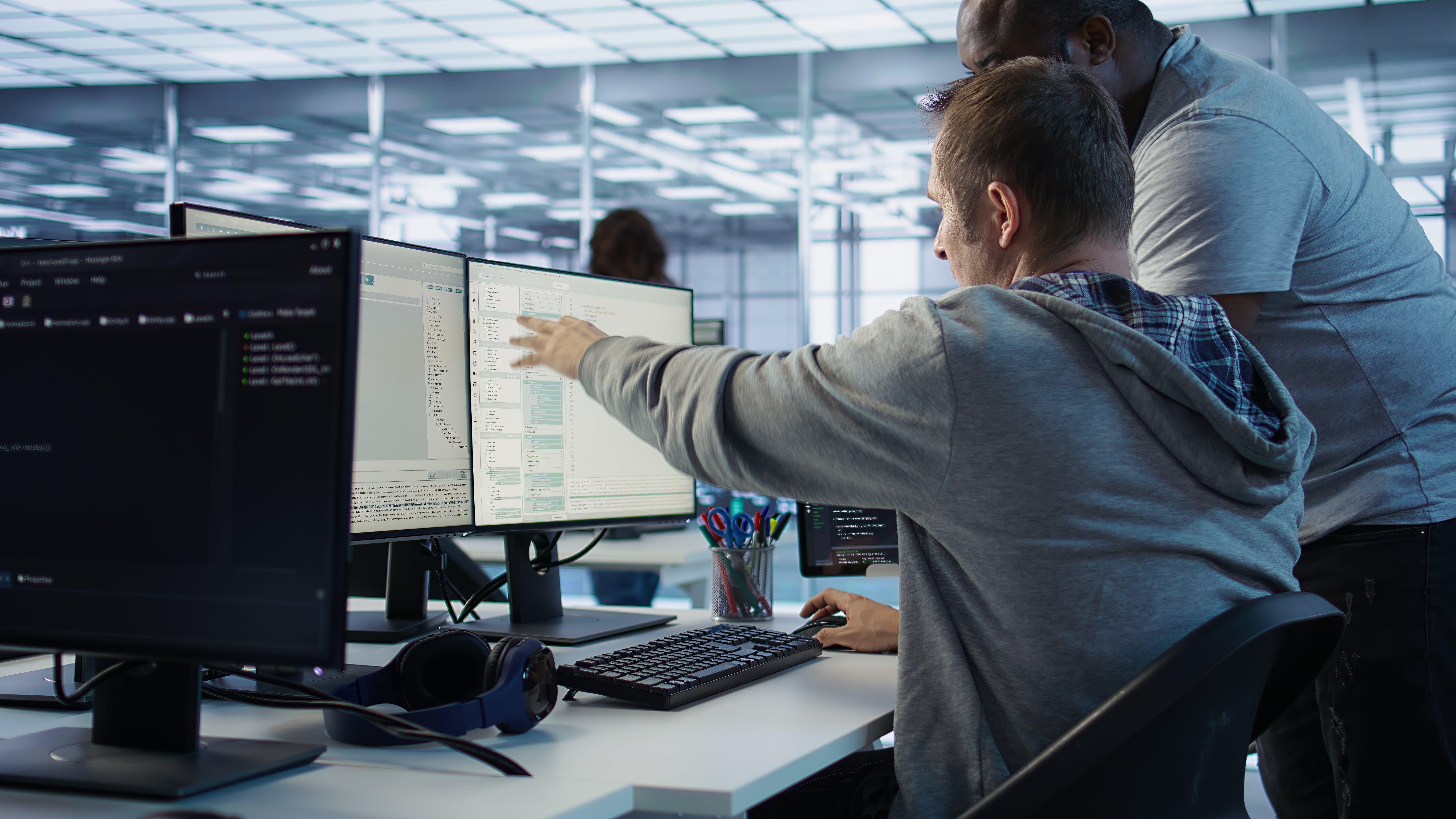 An I.T. employee explaining to a co-worker what is on the screen