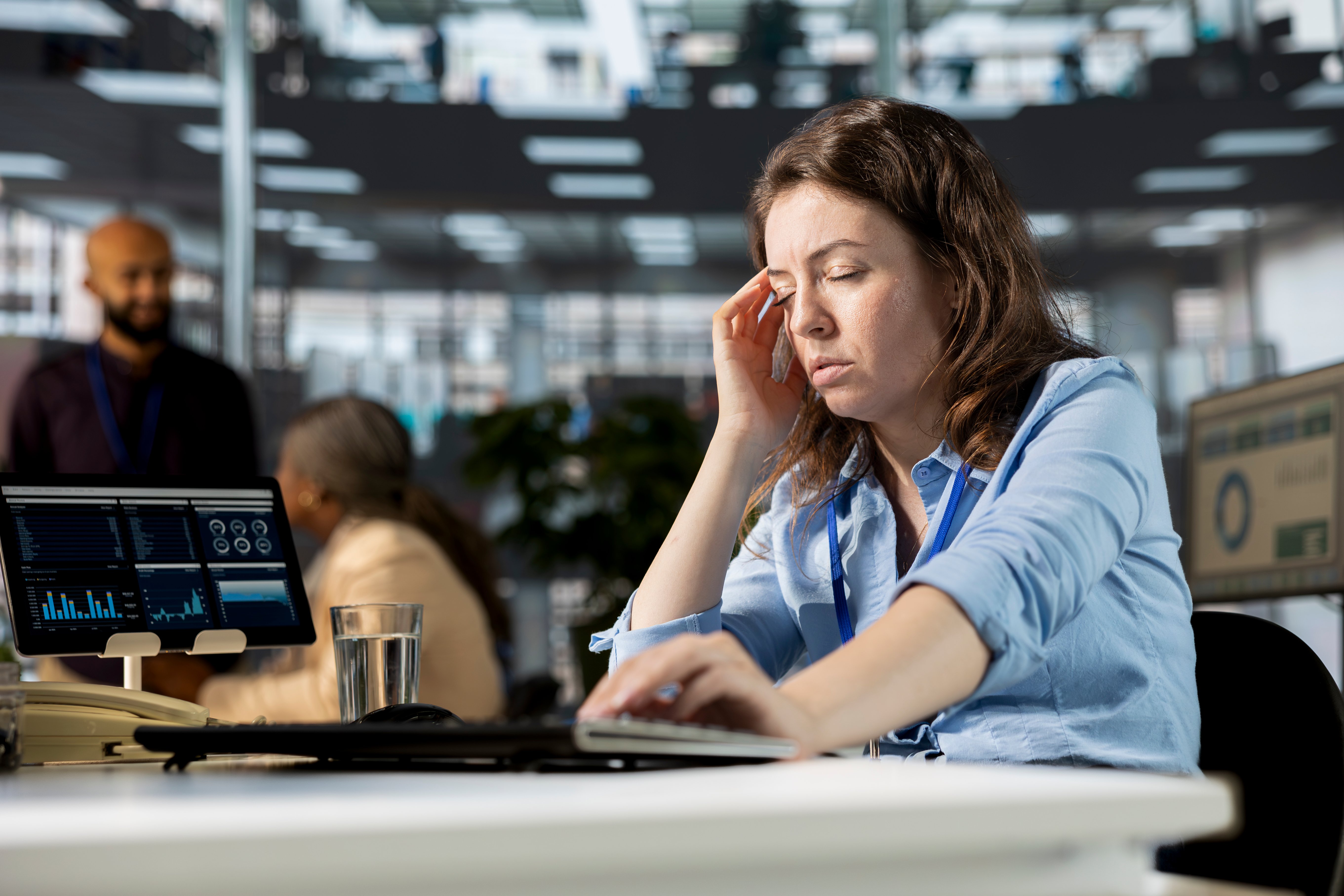 Unwell tired employee deals with a severe headache at the workstation
